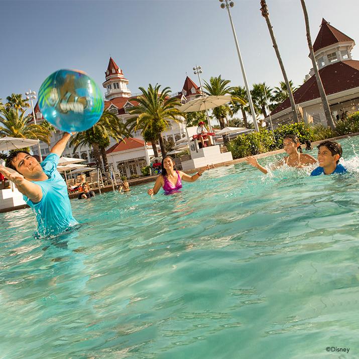 family playing with inflated ball in a resort pool at a Walt Disney World Resort